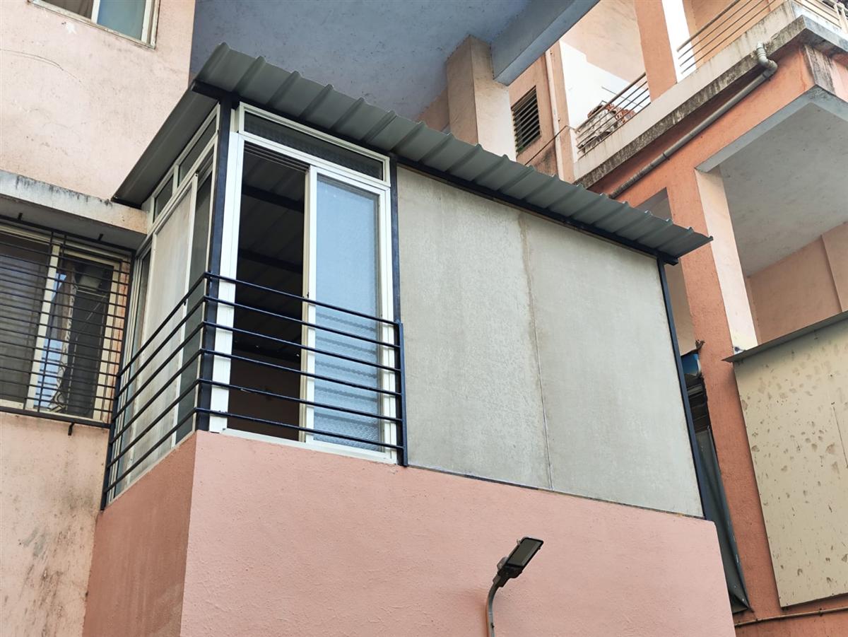 A car parking shed with a strong metal frame and a curved roof design.